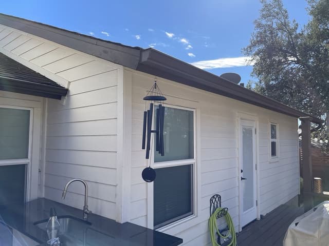 Dark bronze gutters on white siding