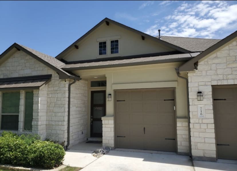 Stone and stucco home with dark bronze gutter system